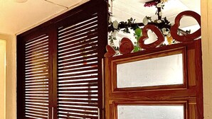 Una habitación con una puerta corredera, una silla de madera, una mesa y un tapete negro con texto.