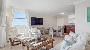 A living room with a sofa, armchairs, a coffee table, and a dining area with a table and chairs.