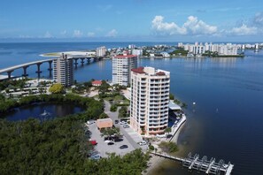 Ett högt hotell med en småbåtshamn och en bro i bakgrunden.