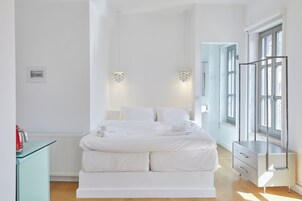Un dormitorio moderno con una cama grande, mesitas de noche y un armario.