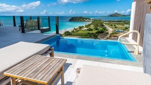 A poolside area with a view of the ocean and a distant island. - Sunset Vista Suite – Panoramic Ocean Retreat at Tamarind Hills, Antigua (Ffryes beach)