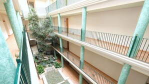 A multi-level atrium with a central garden area, multiple balconies, and a glass floor section. - Golden Beach by Interhome (St Carles de la Ràpita)