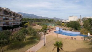 A resort with a swimming pool, a walking path, and a view of mountains. - Golden Beach by Interhome (St Carles de la Ràpita)