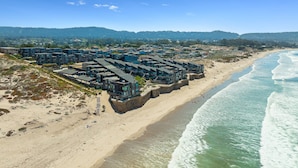 Un hotel costero con varias construcciones a lo largo de la playa, con balcones y vistas al océano.