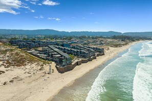 A coastal hotel with multiple buildings, a sandy beach, and ocean views. - Ocean Harbor 130 - Monterey Condo - Surf Sounds (Monterey)