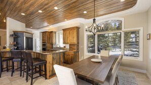 Una cocina amplia con armarios de madera, una isla grande y una zona de comedor con banco.