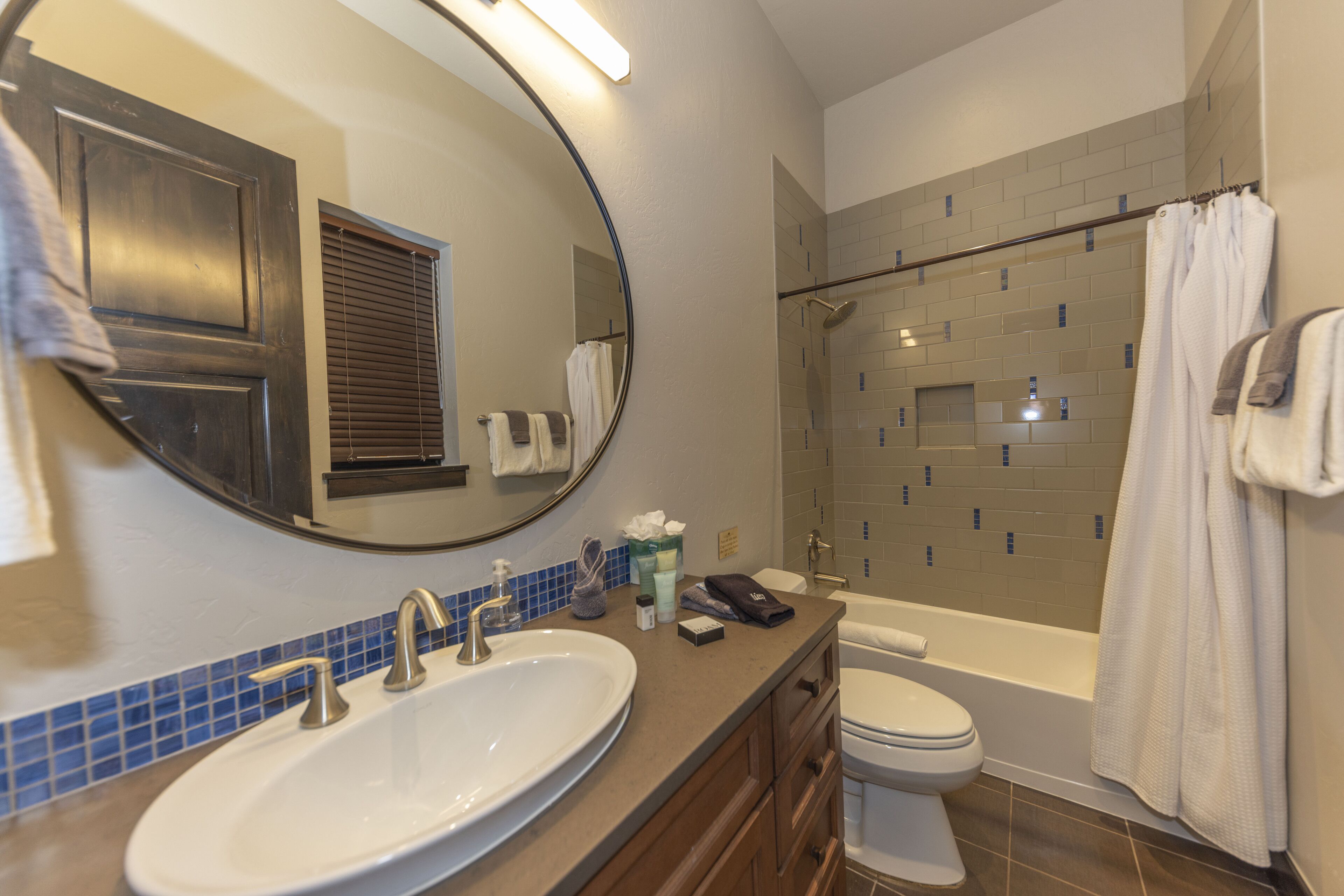 Een badkamer met een groot ovaal wastafel, toilet, bad en douche.