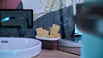 A bathroom with a white sink, a mirror, and a tissue box containing tissues.