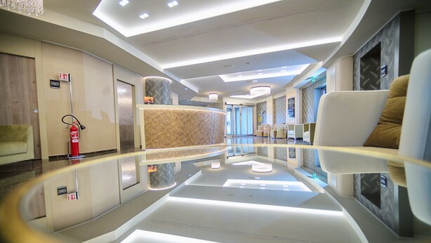 A modern hotel lobby with a reflective floor, a reception desk, and seating areas. - PARK HOTEL LE DUNE DI GIOVINO (Catanzaro)