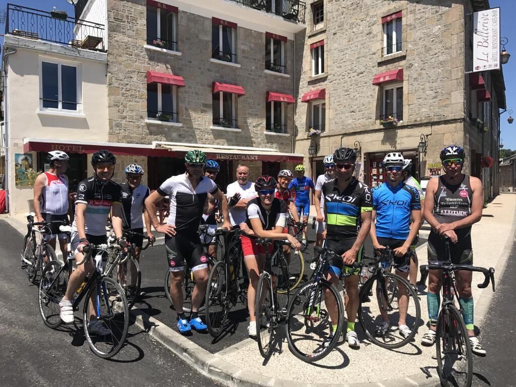 Un grupo de ciclistas frente a un edificio con un letrero de restaurante.