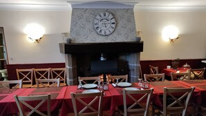 Un restaurante con mesas dispuestas para comer, una chimenea y un reloj en la pared.