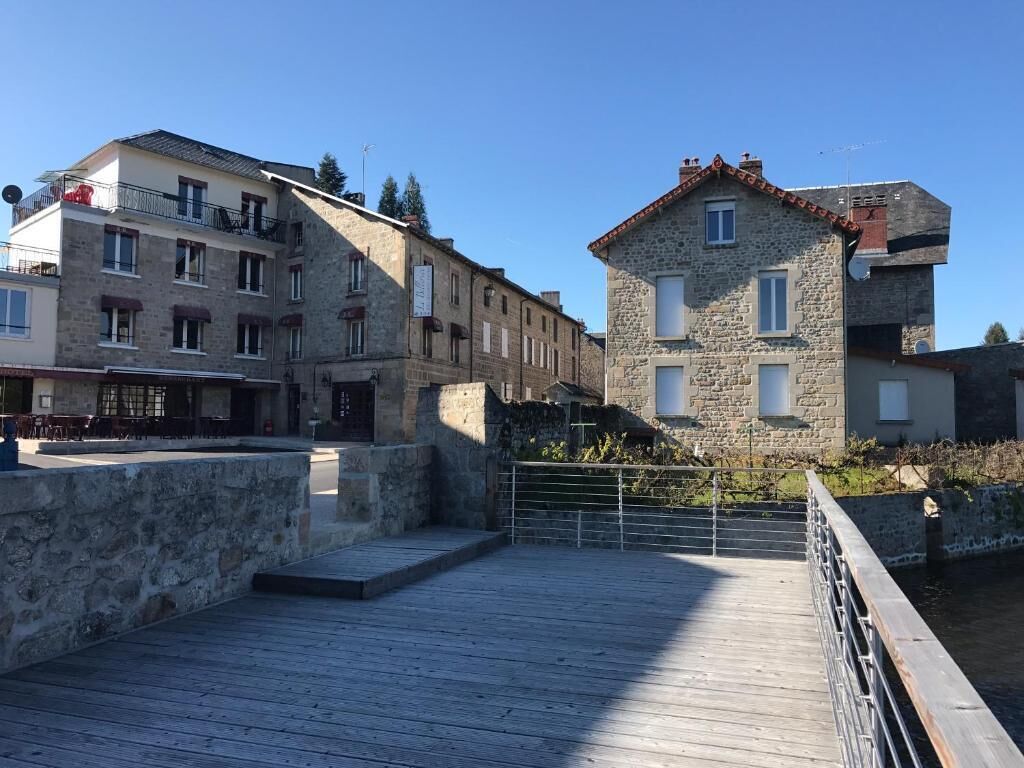 A wooden boardwalk leading to stone buildings with balconies and windows.