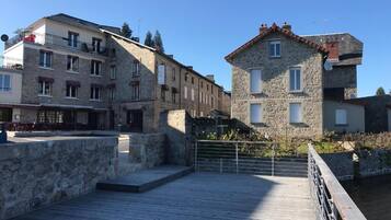 A wooden boardwalk leading to stone buildings with balconies and windows.
