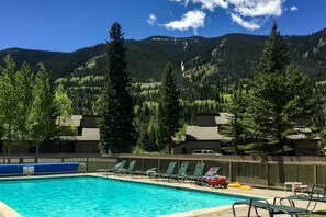 Relax by the serene pool surrounded by lush greenery and majestic mountains.