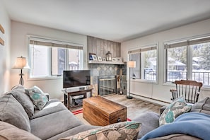 Relax in this inviting living room with a comfortable sofa, flat-screen TV, and fireplace.