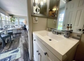 A modern bathroom with a large sink, double vanity, and a large mirror.