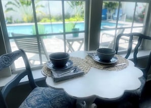 A dining table with two bowls and a spoon, set on a woven placemat.