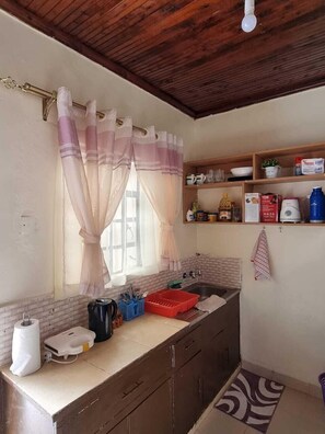 Køleskab, mikrobølgeovn, køkkentøj/tallerkener/redskaber, spisebord