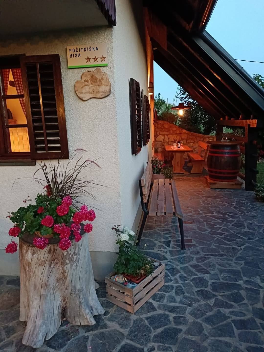 A rustic building with a stone floor, wooden benches, a barrel, and a sign indicating a 5-star rating.