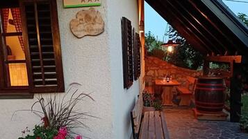 A rustic building with a stone floor, wooden benches, a barrel, and a sign indicating a 5-star rating.