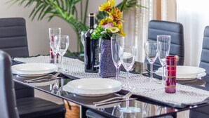 A dining table set with plates, glasses, and a decorative vase with flowers. - Villa 'Galicia' with Mountain View, Private Pool and Wi-Fi (Calpe)