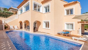 A large building with a swimming pool, multiple windows, and outdoor seating areas. - Villa 'Galicia' with Mountain View, Private Pool and Wi-Fi (Calpe)