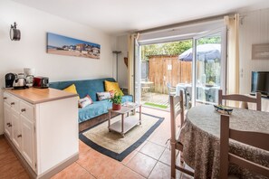 Un salon confortable avec un canapé, une table basse et une table à manger avec des chaises.