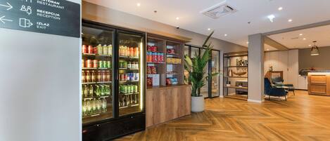 A reception area with a sign indicating the restaurant, reception, and exit. There is a refrigerated display case with beverages and snacks.