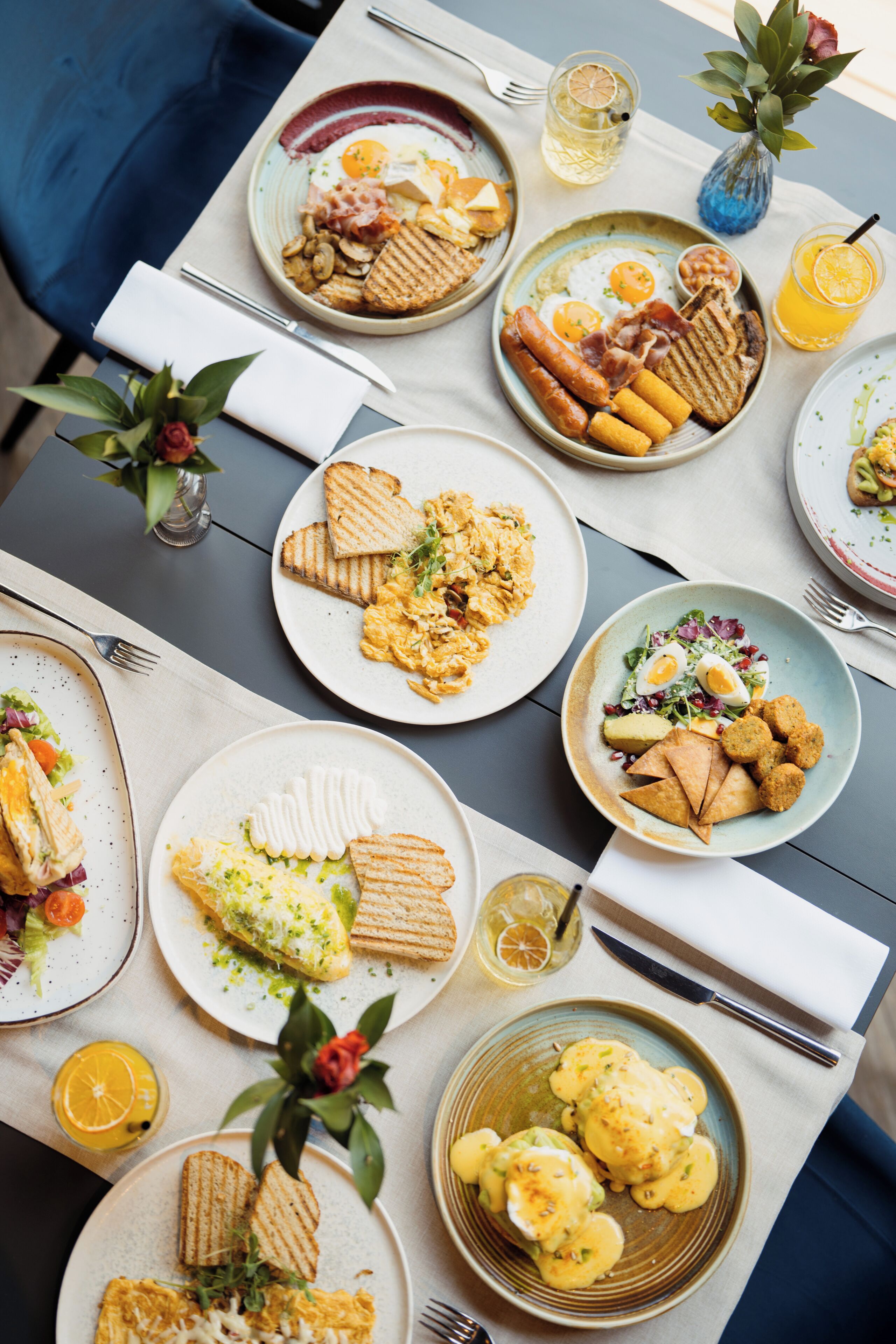 A table set with various breakfast dishes, including eggs, sausages, and toast.