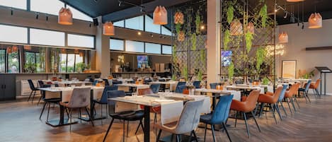A spacious restaurant with high ceilings, pendant lighting, and a modern interior design.