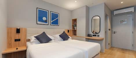 Una habitación de hotel moderna con una cama grande, una mesita de noche, un espejo y un armario.