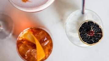 A top-down view of four different drinks, each with unique garnishes.