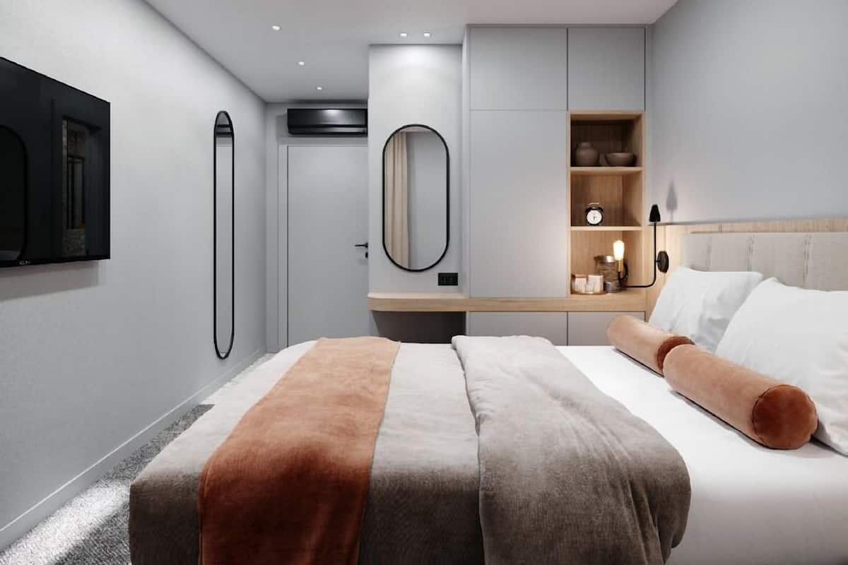 A modern bedroom with a bed, bedside table, and built-in shelving.