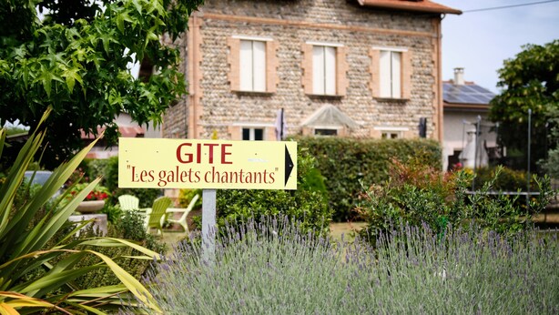 A stone building with a sign that reads 'GITE Les galets chantants.'