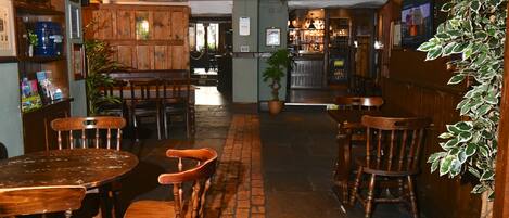 A cozy restaurant with wooden furniture and brick flooring.