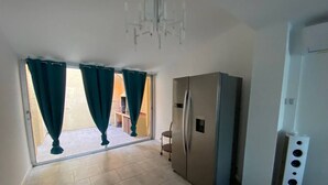 A room with a sliding glass door, a built-in refrigerator, and a white speaker unit. - 5-Bedroom Marina with A/C, Pool, Private Pontoon, Sleeps 8 - Port Barcarès (Le Barcarès)