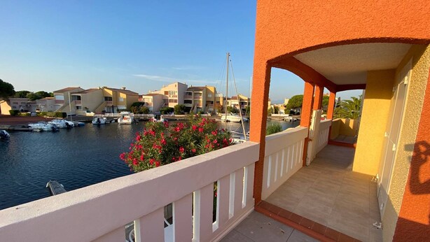 A balcony with a view of a marina and buildings. - 5-Bedroom Marina with A/C, Pool, Private Pontoon, Sleeps 8 - Port Barcarès (Le Barcarès)