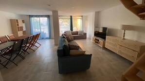 A spacious living area with a sofa set, a TV, and a dining area with chairs and a table. - 5-Bedroom Marina with A/C, Pool, Private Pontoon, Sleeps 8 - Port Barcarès (Le Barcarès)