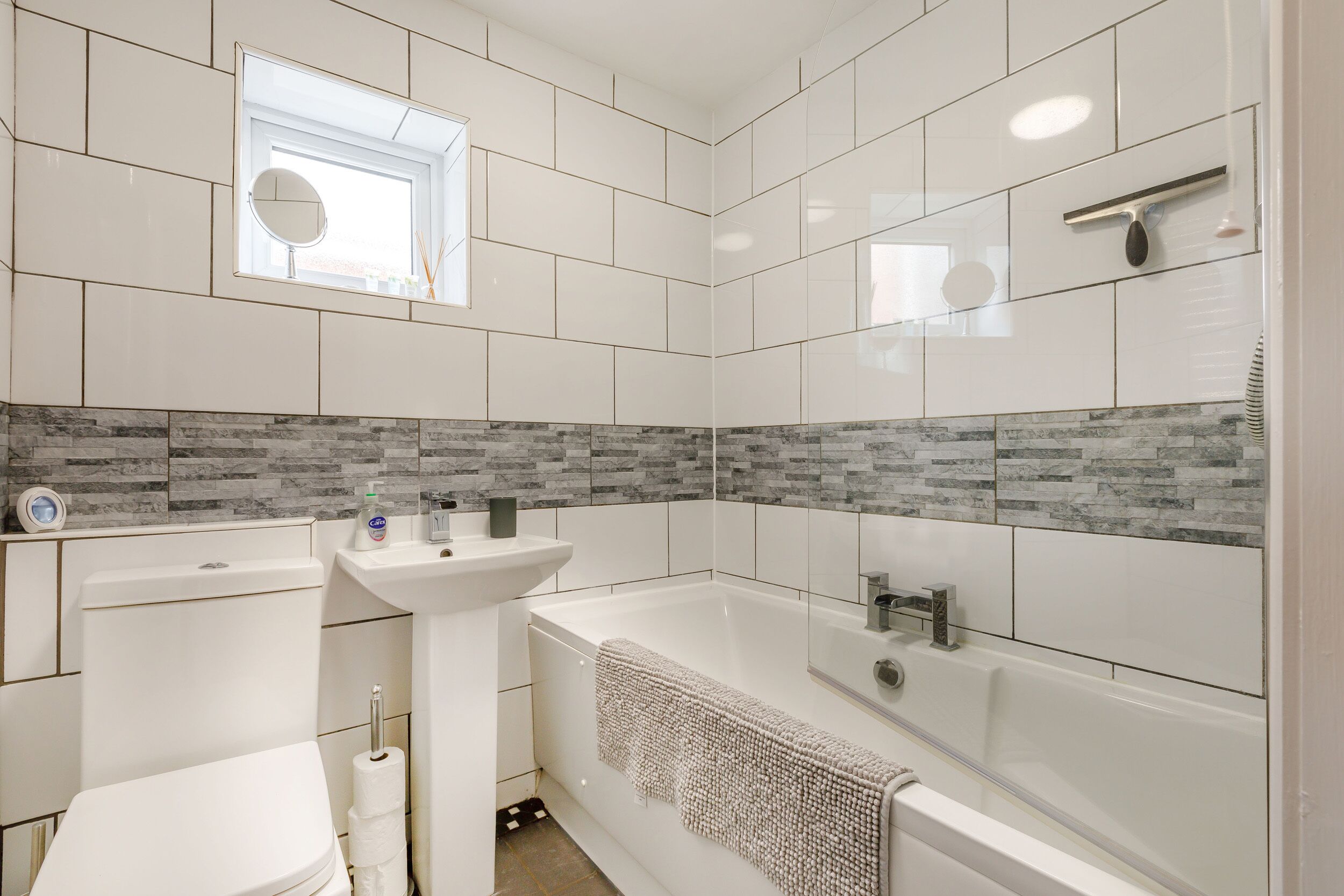 Ein modernes Badezimmer mit Toilette, Waschbecken und Badewanne.
