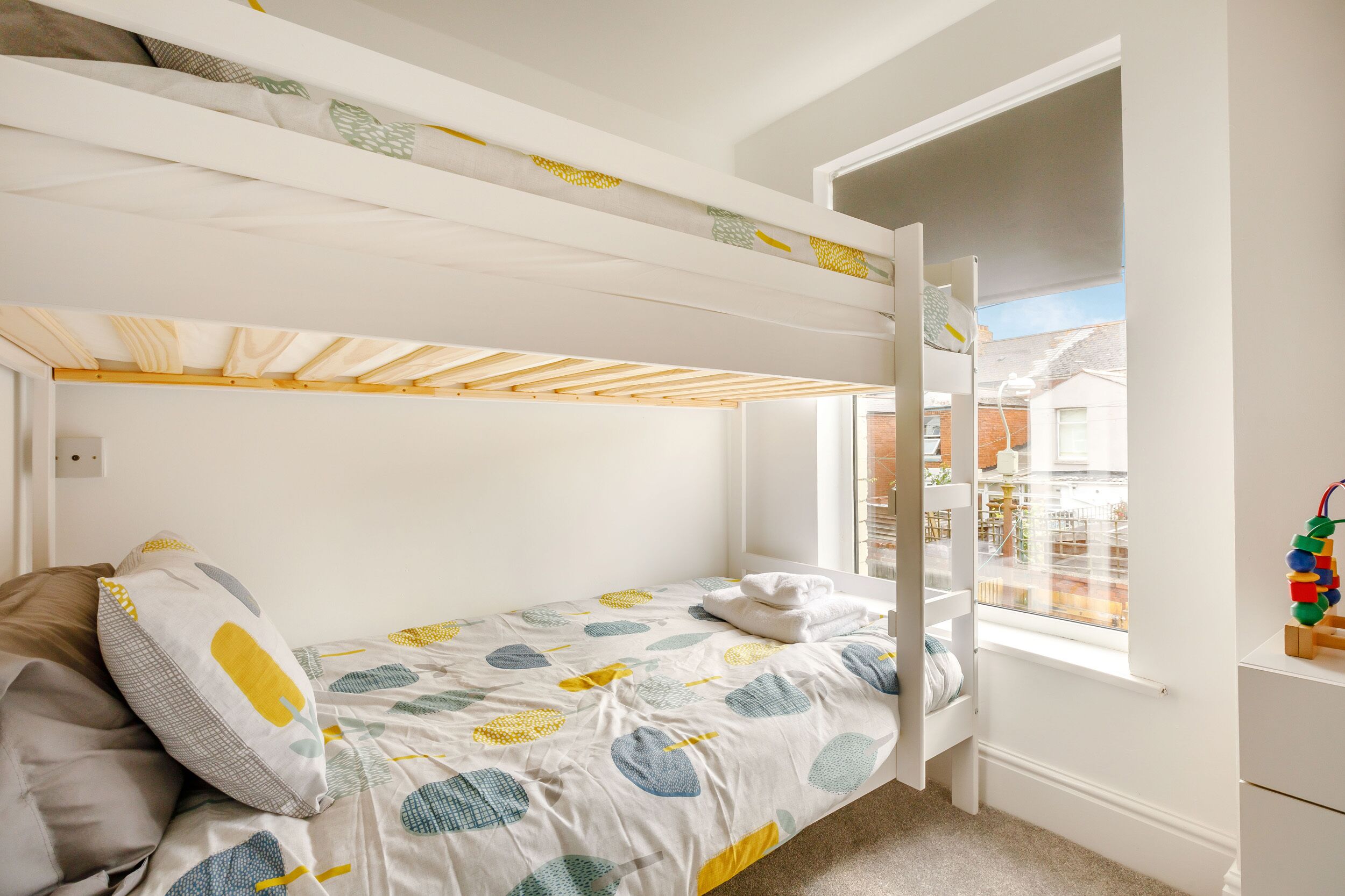 Habitación con literas, una mesita y vistas al exterior.