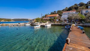A coastal marina with clear blue waters, wooden docks, and several boats. - Awesome apartment in Supetarska Draga with WiFi (Supetarska Draga)