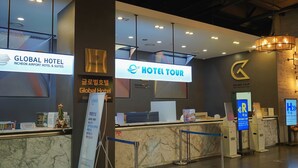 A hotel reception area with a marble counter, a reception desk, and a sign for the Global Hotel. - Hotel Tour (Incheon)