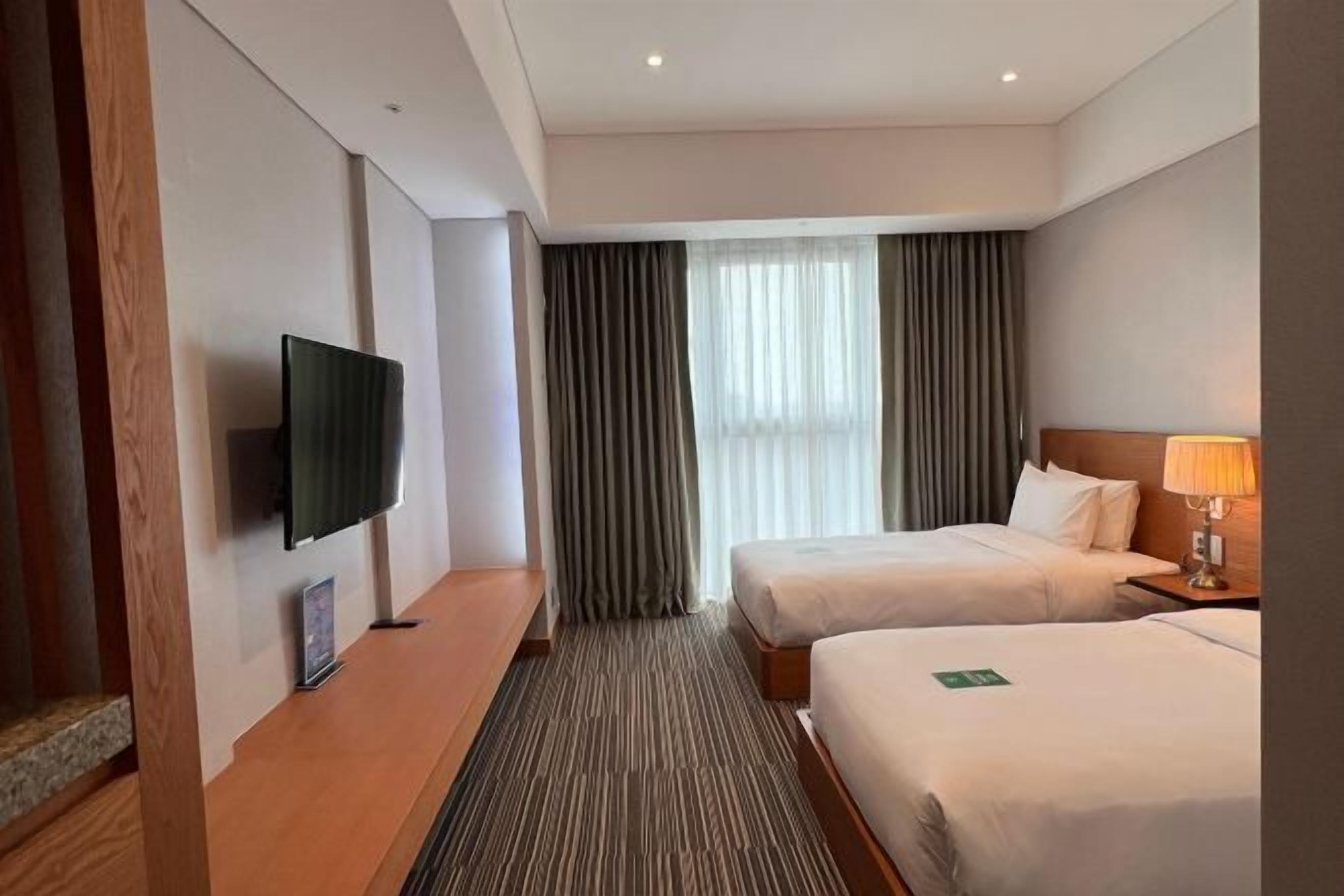 Minibar gratis, tirai kedap cahaya, kedap suara, dan seprai linen