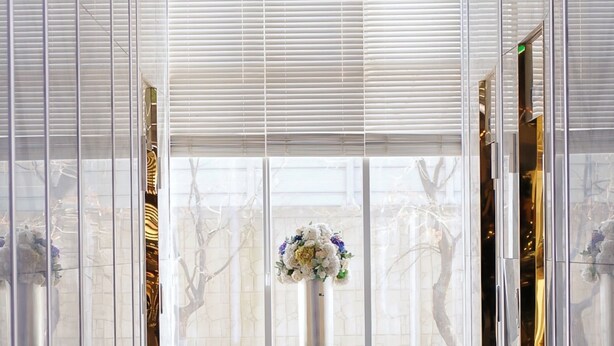 A modern interior with a central floral arrangement, reflective glass panels, and a patterned floor. - Hotel Tour (Incheon)