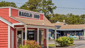 A red building with a sign reading "Bagelhound" and a parking lot in front. - Walk to Restaurants Shopping & Harbor! (Wellfleet)