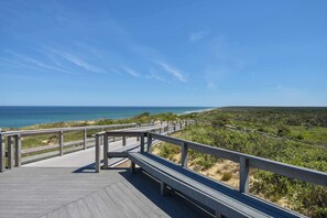 A wooden boardwalk leading to a beach with a clear view of the ocean. - Walk to Restaurants Shopping & Harbor! (Wellfleet)