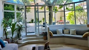 A sunlit room with a curved bench, large windows, and a ceiling fan. - Seaside, magnificent 150m2 apartment with garden (Marseille)
