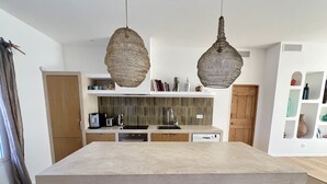 A modern kitchen with a large island, wooden stools, hanging wicker light fixtures, and a tiled backsplash. - Seaside, magnificent 150m2 apartment with garden (Marseille)