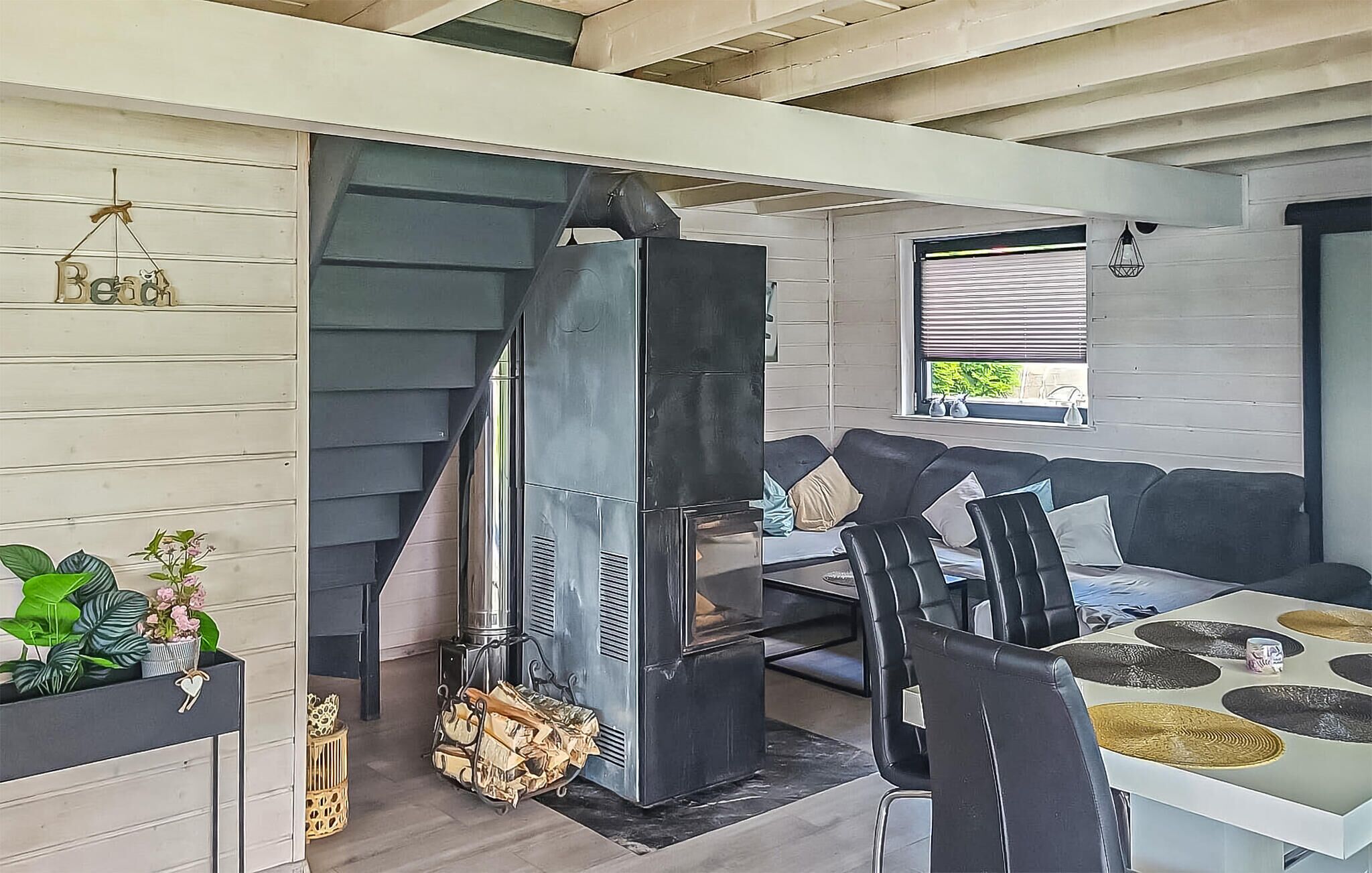 A modern interior with a fireplace, a sofa, and a dining area.