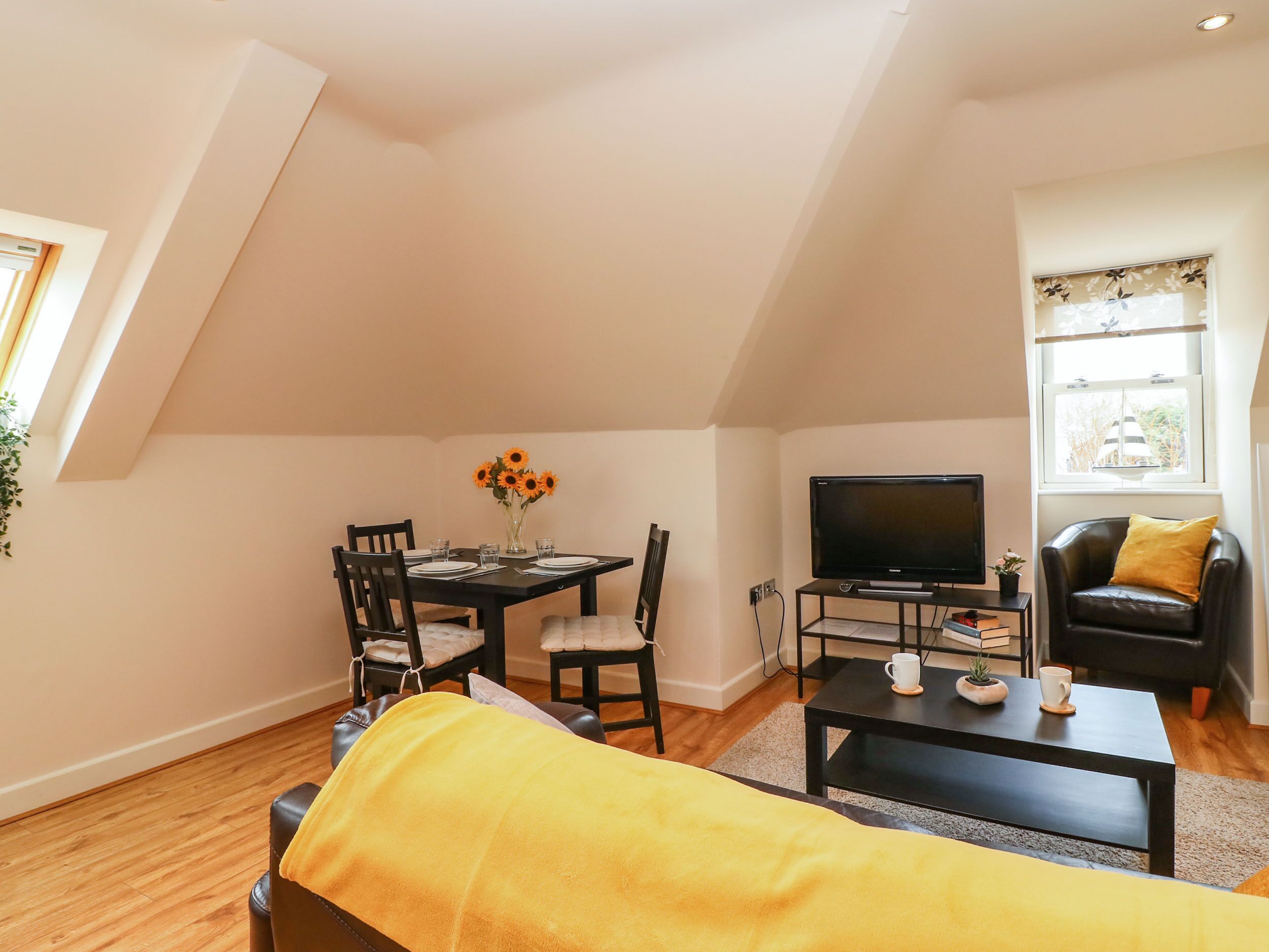 Un appartement en duplex confortable, comprenant un coin repas, un salon et un téléviseur.